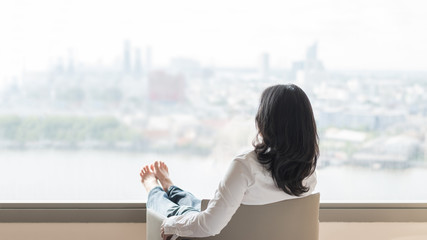 Life quality concept with business woman rear view relaxing sitting in rest on cozy armchair in...