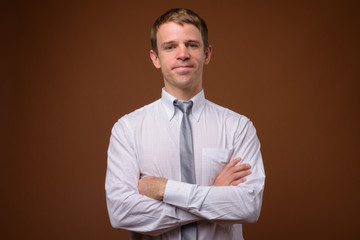 Businessman wearing white shirt against brown background