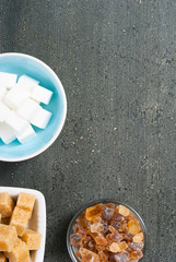 brown and white cubes and rock sugar, dark wood table