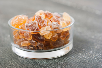 rock sugar in glass pot, on dark wooden surface