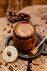 Barrel with fresh delicious honey on a wooden saw.