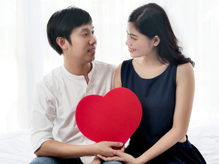 Happy couple in love holding red heart shape, valentine concept.