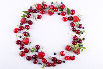 Summer concept. Flat lay, top view, copy space.  Frame made of fresh berries. Strawberry, blueberry and sweet cherry