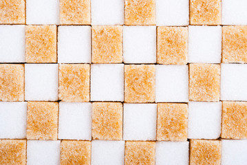 white and brown sugar nubs on black square plate, bright wood table background