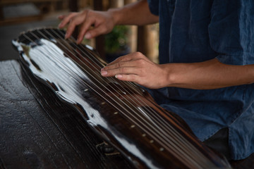 The man is playing the Guqin	