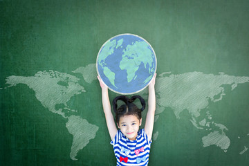 Educated school kid lifting world globe chalk doodle drawing on green chalkboard for education concept