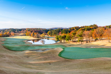 福島の紅葉で早朝のゴルフ場グリーンと水鏡の池