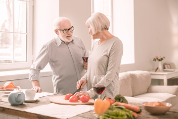 Pleased blonde woman preparing tomatoes for salad