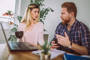 Woman and man doing paperwork together, they report online tax on the laptop.