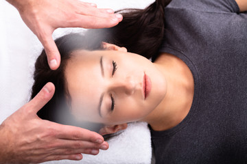Obraz na płótnie Canvas Therapist Giving Reiki Healing Treatment To Woman