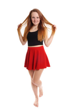 full body shot of young woman wearing red mini skirt playing with hair    