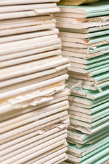Gypsum plasterboard in the pack. The stack of gypsum board preparing for construction. Pallet with plasterboard in the building store. Construction Materials. Drywall warehouse. vertical photo.