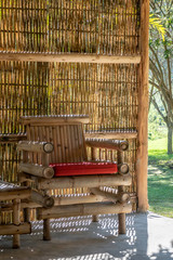 The inside of bamboo furnished house hut cottage with bamboo decoration such as chair sofa and building wall with the natural light from the outside. in the sunny day. 