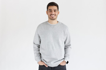 Young man in oversized sweatshirt, isolated on gray background