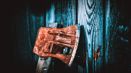 Old ax on the background of a wooden wall. Horror