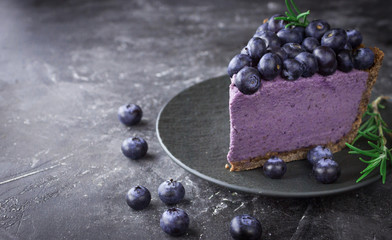 Blueberry vegan cheesecake. Dark photo on black background