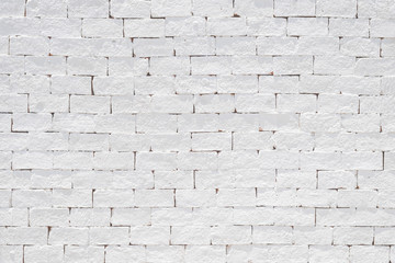 Brick wall texture background painted in white color in grunge style .