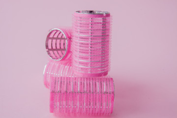Curlers hair plastic on a pink background with copy space