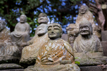 Fototapeta na wymiar Stone figures of Japanese Buddhist monks close-up. Stone figures of seated monks