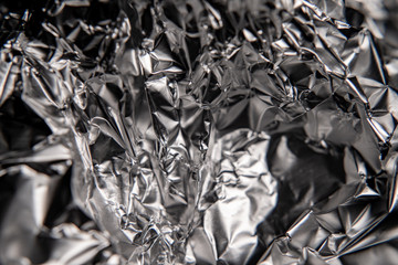 Silver foil closeup texture. Black and white abstract background. Foil crumpled.