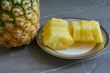 Whole pineapple and pieces of pineapple.
