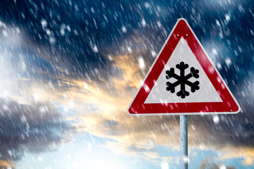 Unwetterwarnung. Verkehrsschild warnt im Winter vor starkem Schneefall auf der Straße