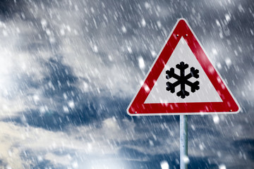 Straßenglätte. Verkehrsschild im Schneegestöber