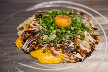 Okonomiyaki, a Japanese pizza / pancake containing a variety of ingredients, on the pan