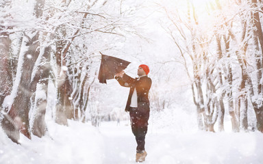 A man on a walk in the park. Young man with in the winter snowfall.