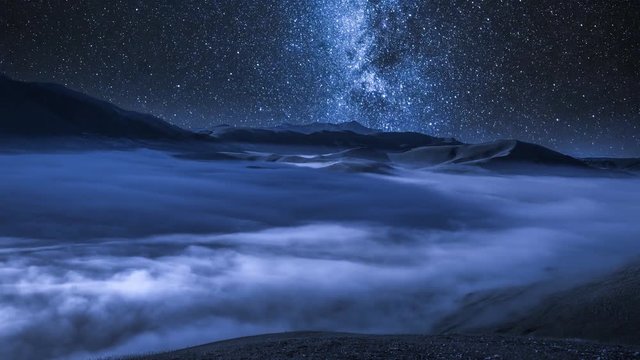 Milky way over flowing clouds in the Tatra Mountains at night, Poland, timelapse, 4K