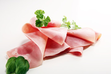 Sliced ham with parsley on table. Fresh prosciutto. Pork ham sliced.