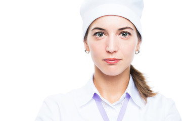 Portrait of young attractive woman medic doctor practitioner in white uniform looking with a smile.