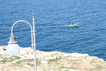 barchetta a motore corre per mare vicino alla costa