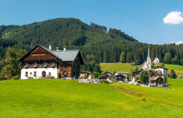 Fototapeta na wymiar Village of Gosau with its wooden houses in the Alps of Austria on a sunny day.