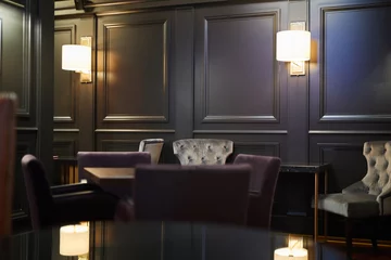 Raamstickers Restaurant Lampen langs zwarte houten wanden, tafels en fauteuils voor gasten van luxe restaurant