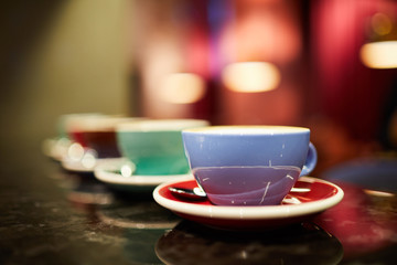 Row of porcelain coffee cups and saucers on table ready for new guests of restaurant or cafe