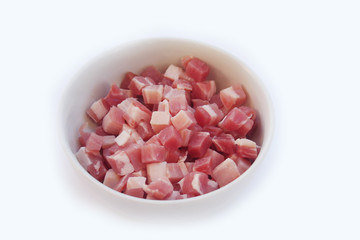 Fresh cubes of bacon in a bowl isolated on white background