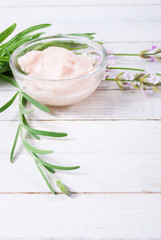 cosmetic cream and lavender flowers on white wood table background