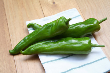 Fresh long green peppers on wooden table. Summer vegetables