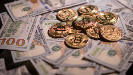 Bitcoin is one of the most famous crypto currency in the world. Lying on the background of American dollars © StockMediaSeller