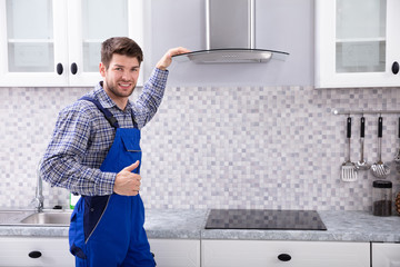 Male Electrician Standing In Front Of Extractor Filter