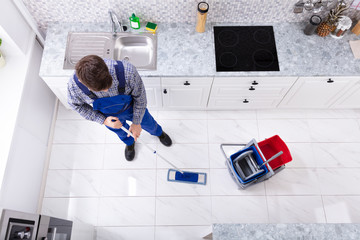 Male Janitor Cleaning Floor With Mop