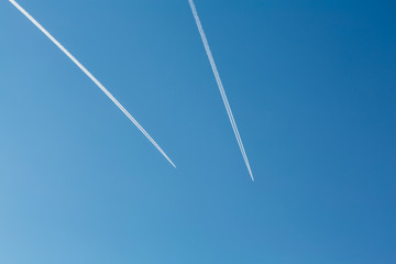 Two planes with traces on a blue sky background.