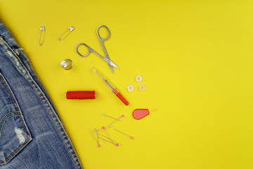 Multiple accessories for sewing view from above on a yellow background.