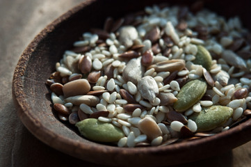 seeds for salads in wooden spoon (flax, pumpkin, sunflower, sesame)