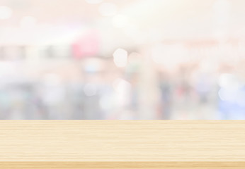 Empty wood table top on blur abstract background from inside shopping mall. Used for display or montage your products