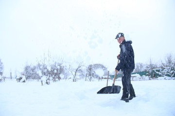 Fototapeta na wymiar man cleans snow in the backyard
