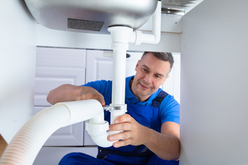 Plumber Repairing Sink Pipe