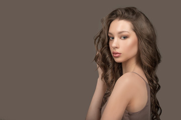Fashion woman portrait. Shiny curly hair, freshness and beauty. Hair and face care