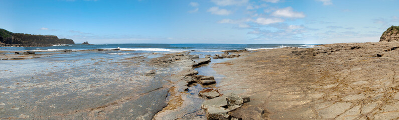 panoramic image looking over rocks to the ocean